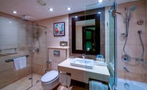 a bathroom with a sink and a shower and a toilet at Holiday Inn AlSeeb Muscat, an IHG Hotel in Muscat
