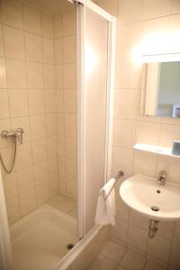 een badkamer met een douche en een wastafel bij Pension Elfmeter in Rheinsberg