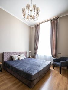 リヴィウにある3 Room Apartments on Galytskaのベッドルーム1室(大型ベッド1台、シャンデリア付)
