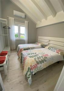 1 dormitorio con 2 camas y ventana en Villa Rosa, en Santillana del Mar