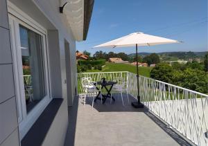 uma varanda com uma mesa e um guarda-chuva em Villa Rosa em Santillana del Mar
