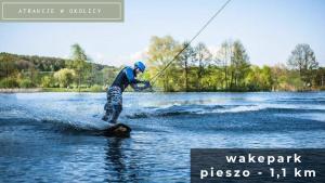 a man is water skiing on a body of water at Szumilas miejsce spotkań in Bydgoszcz +28 photos