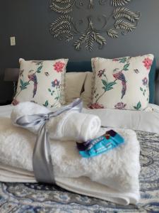 a pile of white towels on a bed with pillows at Palm Beach Guesthouse in Port Elizabeth +233 photos