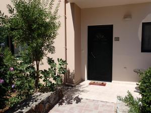 czarne drzwi domu z roślinami w obiekcie Villa Gata w mieście Soúri