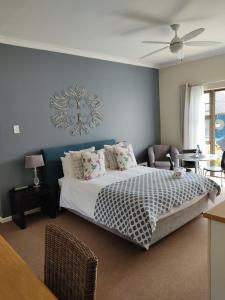 a bedroom with a bed and a blue wall at Palm Beach Guesthouse in Port Elizabeth