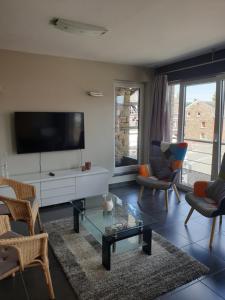 a living room with a tv and a table and chairs at Li Mangon in Francorchamps