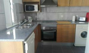 a kitchen with a sink and a stove top oven at Casa dos Avós in Alcácer do Sal