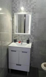 La salle de bains est pourvue d'un lavabo blanc et d'un miroir. dans l'établissement Casa dos Avós, à Alcácer do Sal