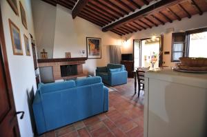 a living room with blue furniture and a fireplace at Linearis Holiday House in Poggibonsi