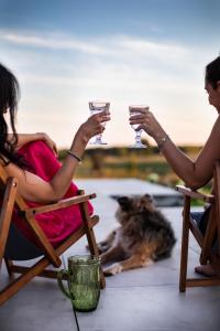 dos personas sentadas en mecedoras sosteniendo copas de vino en Siedlisko Szymonka, en Ryn