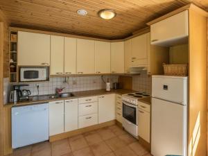 a kitchen with white appliances and a wooden ceiling at Holiday Home Pihlajaniemi by Interhome in Sastamala