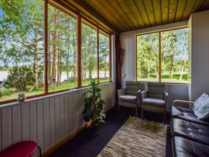 a screened in porch with a couch and windows at Holiday Home Lehtoranta by Interhome in Lankamaa