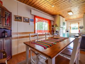 a dining room with a wooden table and chairs at Holiday Home Lehtoranta by Interhome in Lankamaa