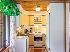una pequeña cocina con armarios amarillos y fregadero en Holiday Home Pikkupuro by Interhome, en Tahkovuori