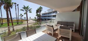 a balcony with a view of the ocean and palm trees at The Edge Apartment in Estepona