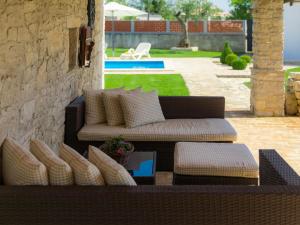 a patio with a couch and a table with pillows at Holiday Home Bozac - ROJ417 by Interhome in Žminj