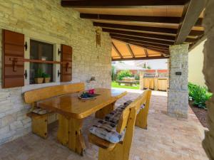 a wooden table and chairs on a patio at Holiday Home Bozac - ROJ417 by Interhome in Žminj