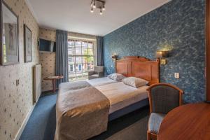 Habitación de hotel con cama y ventana en City Hotel Nieuw Minerva Leiden en Leiden