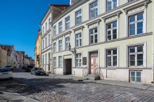 een groot wit gebouw met een rode deur op een straat bij Old Town 2-Bathroom Apartment with Sauna in Tallinn