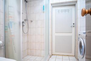 y baño con ducha y lavadora. en Old Town 2-Bathroom Apartment with Sauna, en Tallin