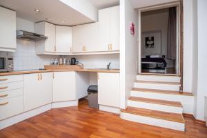 una cocina con armarios blancos y una escalera en Old Town 2-Bathroom Apartment with Sauna, en Tallin