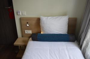 a bed in a small room with a pillow at Hotel Library Amsterdam in Amsterdam