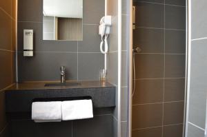 a bathroom with a sink and a phone at Hotel Library Amsterdam in Amsterdam