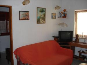 sala de estar con sofá rojo y TV en Medel, en Medulin