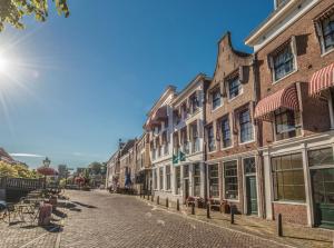 een geplaveide straat in een oude stad met gebouwen bij City Hotel Nieuw Minerva Leiden in Leiden