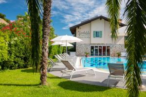 a villa with a swimming pool and palm trees at Residence Verdeblu in Arco