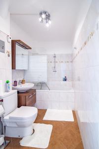 een badkamer met een toilet, een bad en een wastafel bij Best Rated Central Apartment Vienna - AC, WiFi, 24-7 Self Check-In, Board games, Netflix, Prime in Wenen