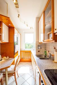 a kitchen with wooden cabinets and a sink and a window at Best Rated Central Apartment Vienna - AC, WiFi, 24-7 Self Check-In, Board games, Netflix, Prime in Vienna