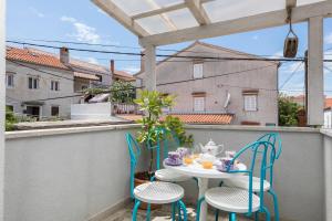 a patio with a table and chairs on a balcony at Casa Maria 2 in Mali Lošinj
