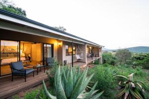 a house with a deck with a cactus at Fugitives Drift Lodge in Rorkeʼs Drift