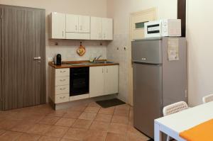 a kitchen with white cabinets and a stainless steel refrigerator at Casa Nocchi in Lucca