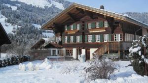 a large wooden house with snow on the ground at Gästehaus Alpenblick Wildstrubel in Sankt Stephan