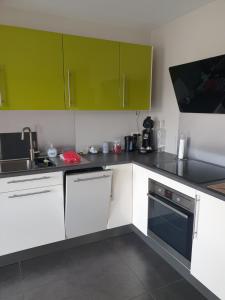 a kitchen with white counters and green cabinets at Li Mangon in Francorchamps