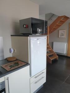 a kitchen with a microwave on top of a refrigerator at Li Mangon in Francorchamps