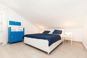 a white and blue bedroom with a bed and a sink at Casa Maria 2 in Mali Lošinj