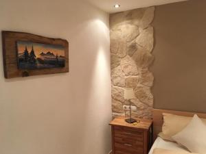Un dormitorio con una cama y una pared de piedra. en Pfeifer Veronika, en Sankt Gallenkirch