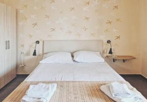 um quarto com uma cama com pássaros na parede em Ammon Garden Hotel em Pefkohori