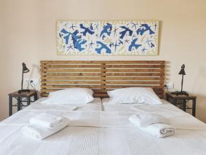 a large white bed with two towels on it at Ammon Garden Hotel in Pefkochori