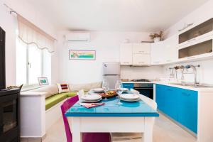 a kitchen with blue and white cabinets and a table at Casa Maria 2 in Mali Lošinj