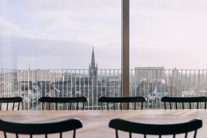 een tafel en stoelen met uitzicht op de stad bij De Hoorn in Leuven