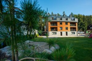 a large building with trees in front of it at Apartmány Hromovka in Špindlerův Mlýn