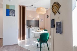 una cucina e una sala da pranzo con tavolo e sedie di Travel Homes - Le GreenBay, Adorable et agréable a Mulhouse
