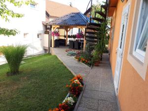 - un jardin fleuri sur le côté du bâtiment dans l'établissement IRIS Room & Apartment, à Slunj