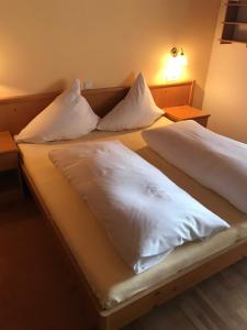 2 Betten in einem Zimmer mit weißer Bettwäsche und Kissen in der Unterkunft Pfeifer Birgitt in Sankt Gallenkirch