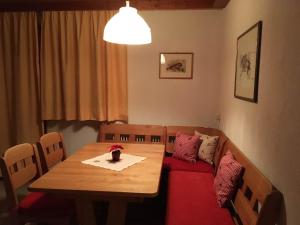 einen Esstisch und ein Sofa mit einem roten Kissen in der Unterkunft Pfeifer Birgitt in Sankt Gallenkirch