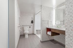 a white bathroom with a toilet and a sink at Holiday Inn - Columbus, an IHG Hotel in Columbus